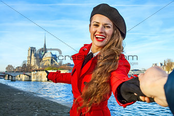 traveller woman holding friends hand and pointing at Notre Dame 