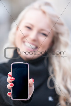 woman showing mobile phone outdoors