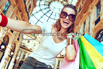 Fashion woman with shopping bags taking selfie in Galleria