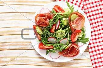 Salad with parma ham, arugula and tomatoes