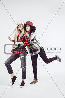 Studio lifestyle portrait of two best friends hipster girls going crazy and having great time together. Isolated on white background.