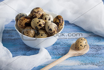 Quail eggs in bowl wooden spoon and gauze