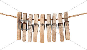 Many old wooden clothespins on a rope isolated