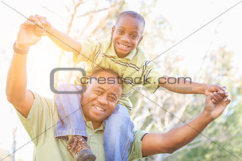 Happy African American Father and Son Riding Piggyback Outdoors