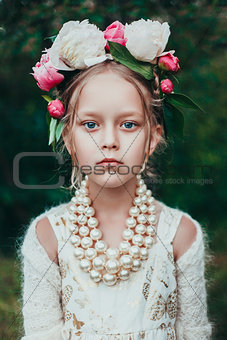 Portrait of a little girl with wreath of peony flowers