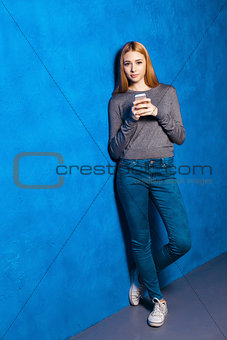 Cute girl against blue wall