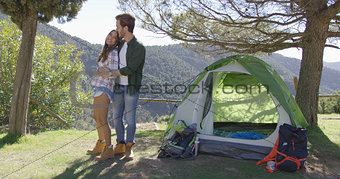 Loving couple kissing near tent