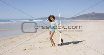 Female posing on beach with surfboard