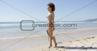 Female with flippers standing on beach
