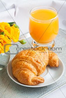 Morning breakfast with croissant and orange juice.