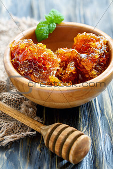 Wooden bowl with honey and honey dipper. 