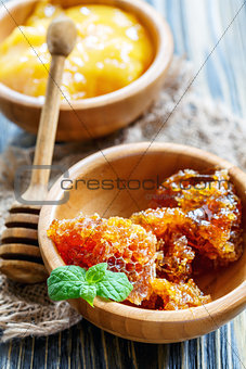  Flower honey in a wooden bowls and honey dipper.