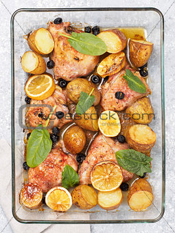 Baked chicken leg quarter with potatoes and lemon