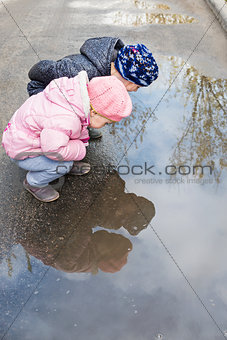 Two children near a puddle