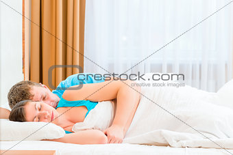 husband tenderly embracing his beloved wife in bed