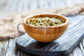 Pumpkin seeds in a wooden bowl.
