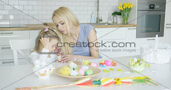 Mother and daughter coloring eggs
