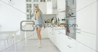 Lovely young girl dancing in kitchen