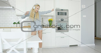 Expressive young girl dancing in kitchen