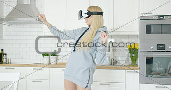 Woman in VR glasses in kitchen