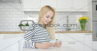 Smiling female using credit card and phone