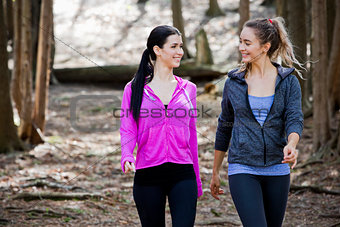 two women wlaking in the middle of the woods