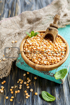 Wooden bowl with yellow peas.
