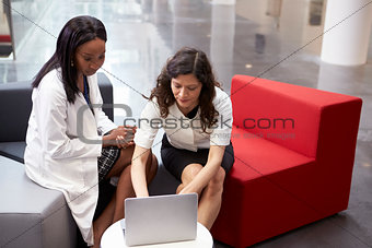 Doctor And Patient Having Meeting In Hospital Reception Area