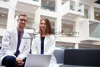 Portrait Of Two Doctors Meeting In Hospital Reception Area