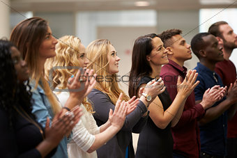 Adult students applauding at an event in their university