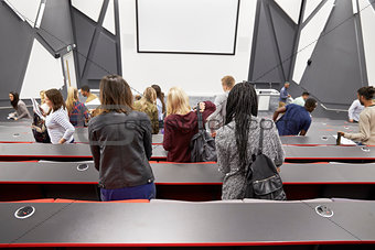 Students leaving university lecture theatre, back view