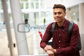 Young adult male student in modern university lobby