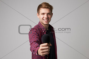 Studio Portrait Of Male Journalist With Microphone
