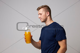Studio Portrait Of Male Nutritionist With Drinks Bottle