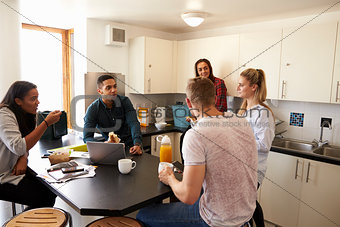 Students Relaxing In Kitchen Of Shared Accommodation