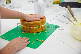 Close Up Of Woman In Bakery Preparing Cake For Decoration