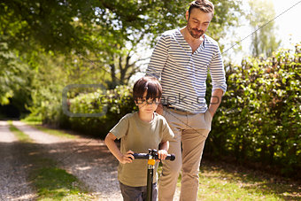 Father And Son Going For Walk In Summer Countryside