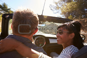 Couple driving, woman looking at man, close up back view