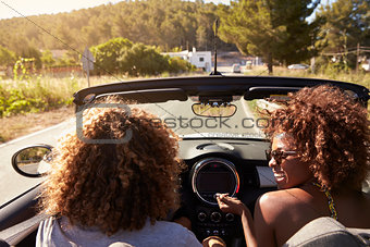 Happy young couple driving in an open top car, Ibiza, Spain