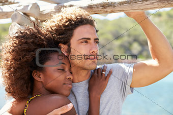 Young couple embracing outdoors, woman looking to camera
