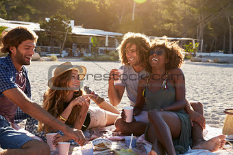 Two couples having a picnic on the beach, lens flare, Ibiza
