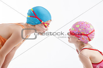 Two girls in swimming suits look at each other