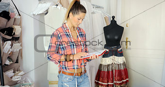 Woman with tablet in tailor's shop