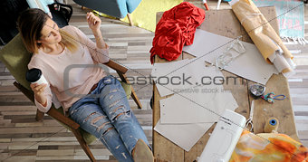 Female tailor having rest in workshop