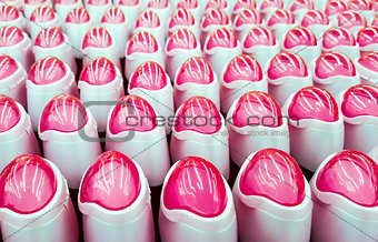 Deodorant, bottles with pink lids in a row.