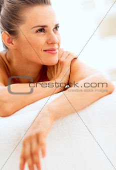 Happy young woman laying on massage table