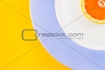 Top view of single grapefruit slice on plate diagonally placed.