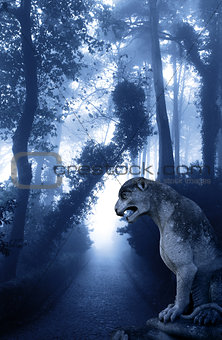 Mysterious landscape with ancient lion statue in misty forest