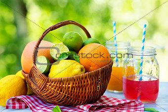 Mix of fresh citrus fruits in basket and juice