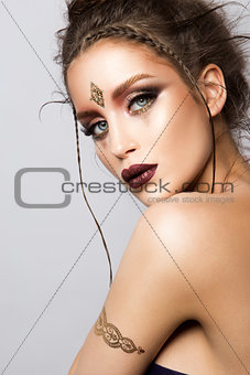 Glamour portrait of beautiful woman model with gold makeup and romantic hairstyle.